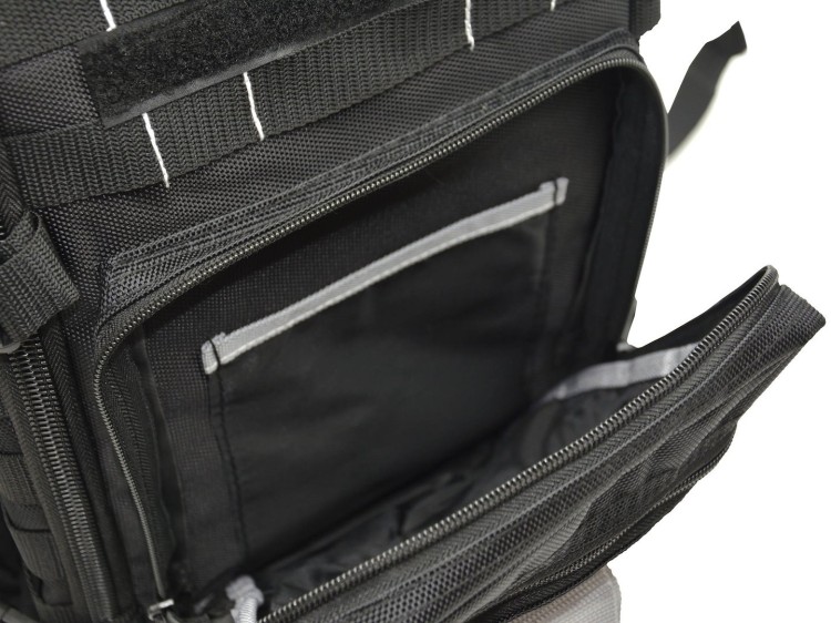 Otwarty czarny plecak monterski z widoczną wewnętrzną kieszenią na narzędzia i dokumenty