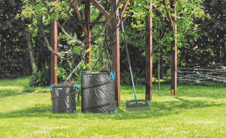 Dwa składane kosze ogrodowe i grabie na trawie