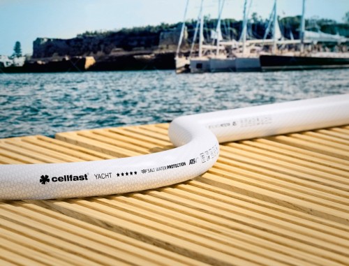 Biały wąż Cellfast YACHT na drewnianym pomoście przy wodzie