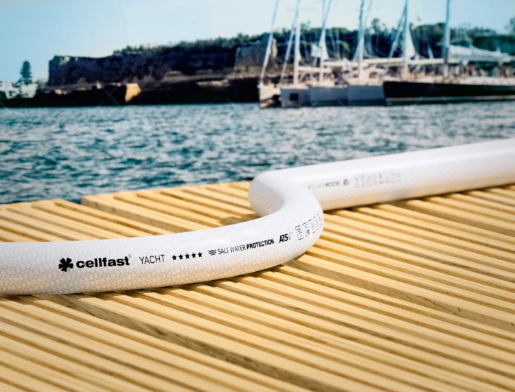 Biały wąż Cellfast YACHT na drewnianym pomoście przy wodzie